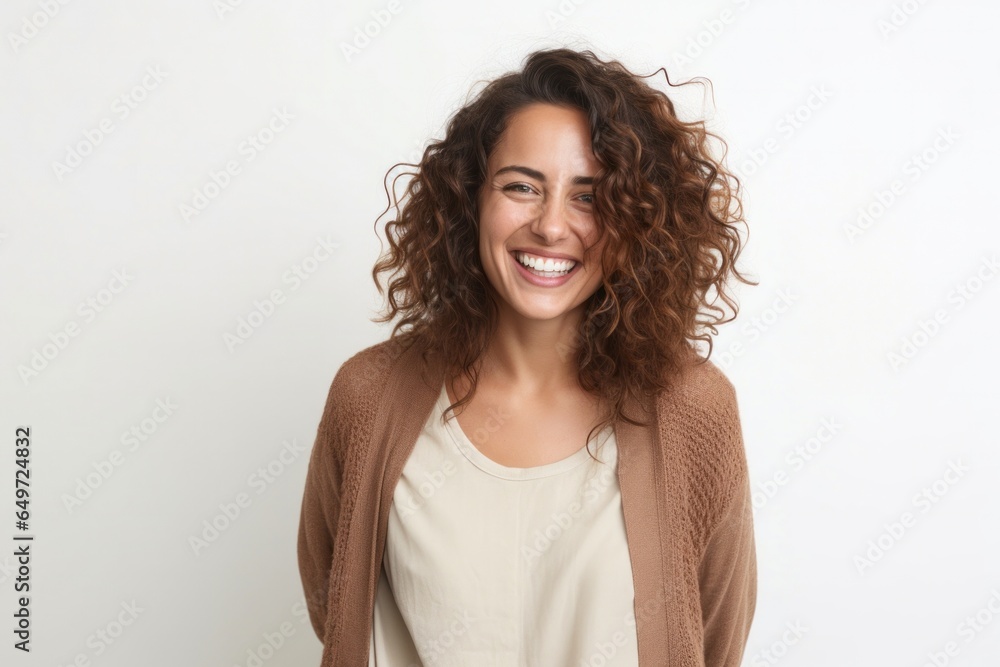 portrait of a happy Israeli woman in her 30s wearing a chic cardigan against a white background