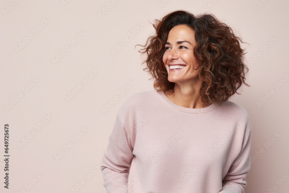 medium shot portrait of a happy Israeli woman in her 40s wearing a cozy sweater against a pastel or soft colors background medium shot portrait of a happy Israeli woman in her 40s wearing a cozy sweater against a pastel or soft colors background