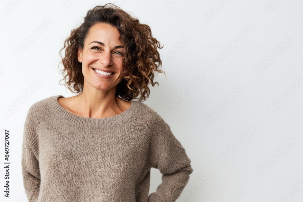 portrait of a happy Israeli woman in her 40s wearing a cozy sweater against a white background