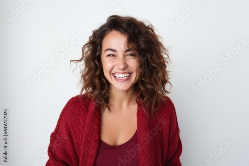 medium shot portrait of a happy Mexican woman in her 30s wearing a chic cardigan against a white background © Anne-Marie Albrecht