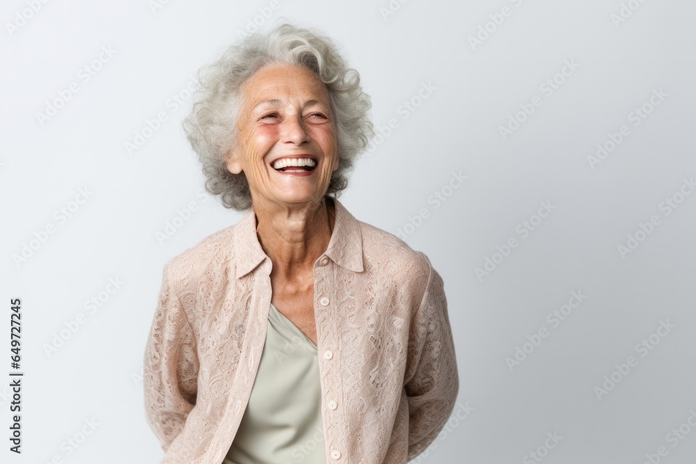 portrait of a happy Israeli woman in her 70s wearing a chic cardigan against a white background portrait of a happy Israeli woman in her 70s wearing a chic cardigan against a white background