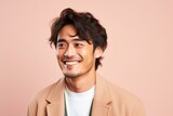 portrait of a happy Japanese man in his 20s wearing a chic cardigan against a pastel or soft colors background