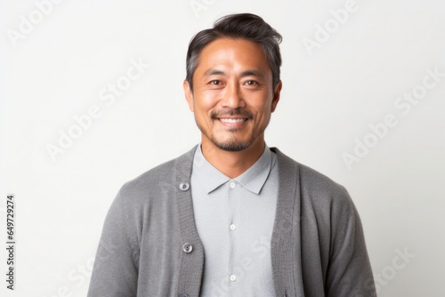 medium shot portrait of a Japanese man in his 40s wearing a chic cardigan against a white background