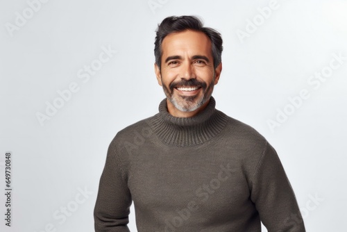 medium shot portrait of a Mexican man in his 40s wearing a cozy sweater against a white background © Anne-Marie Albrecht