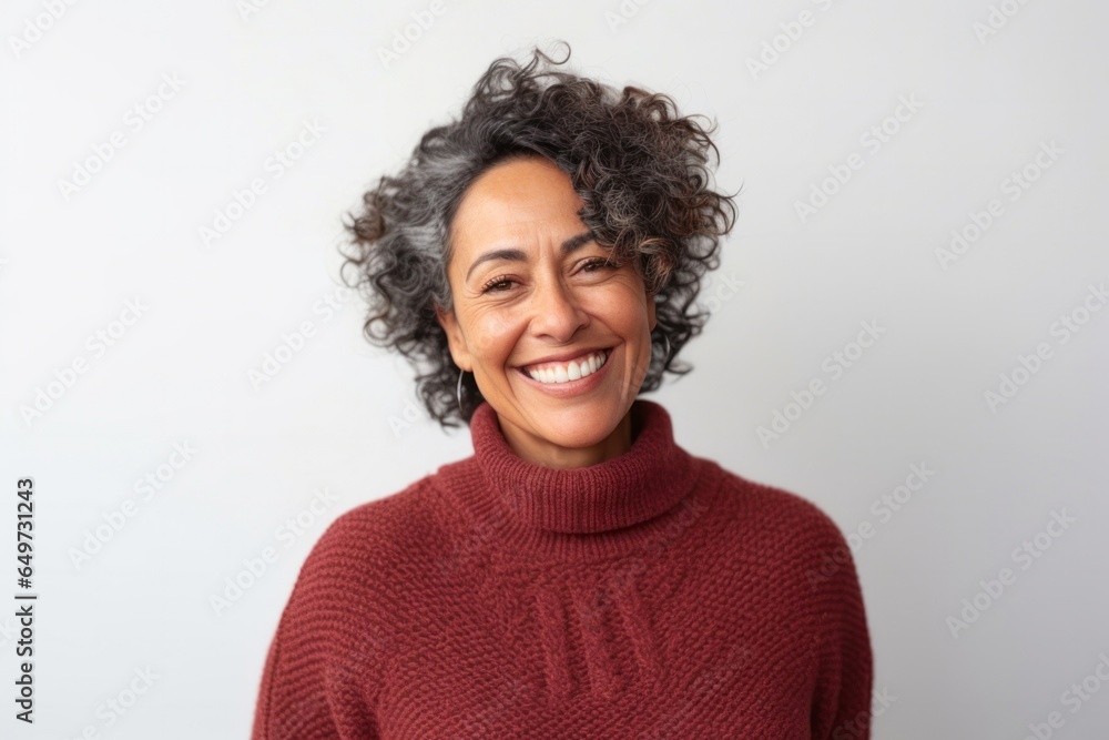 medium shot portrait of a Mexican woman in her 50s wearing a cozy sweater against a white background - obrazy, fototapety, plakaty 