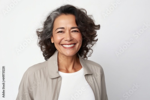 medium shot portrait of a Mexican woman in her 50s wearing a chic cardigan against a white background