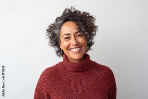 medium shot portrait of a Mexican woman in her 50s wearing a cozy sweater against a white background