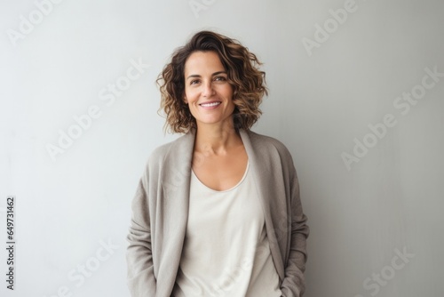portrait of a Israeli woman in her 40s wearing a chic cardigan against a minimalist or empty room background