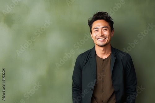 portrait of a Japanese man in his 30s wearing a chic cardigan against an abstract background