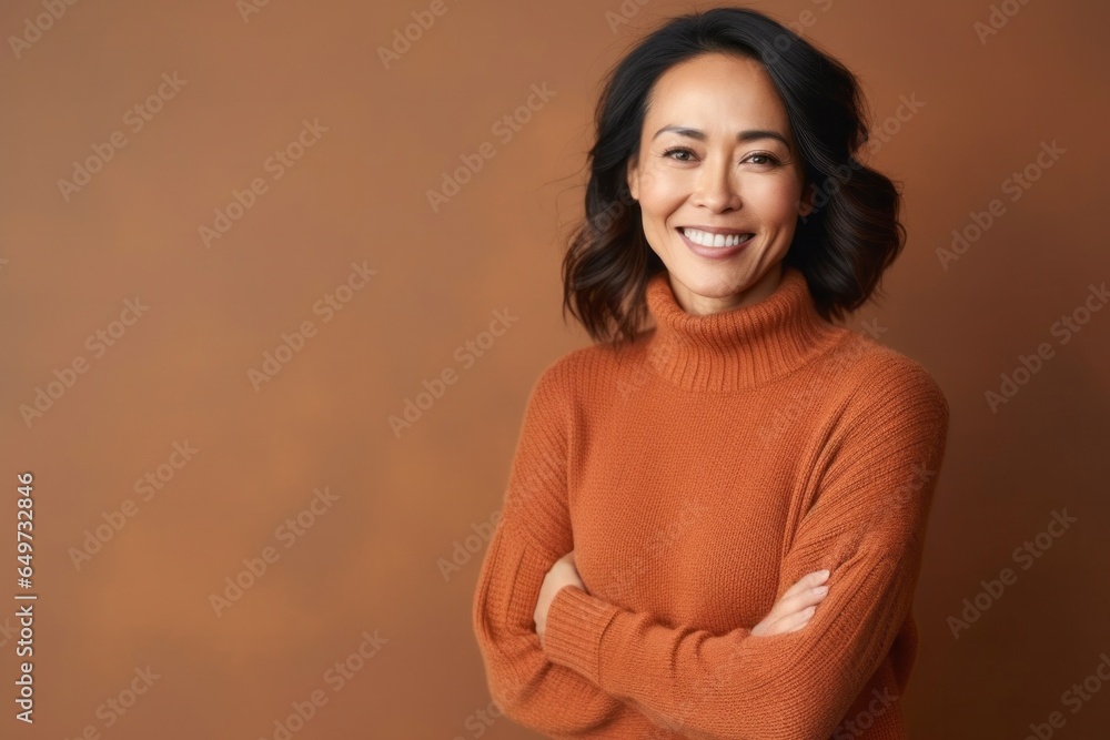 Obraz premium medium shot portrait of a confident Filipino woman in her 40s wearing a cozy sweater against an abstract background