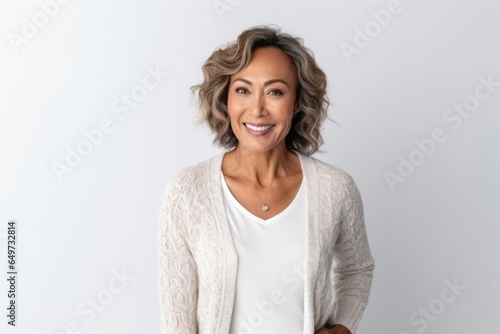 medium shot portrait of a confident Filipino woman in her 40s wearing a chic cardigan against a white background