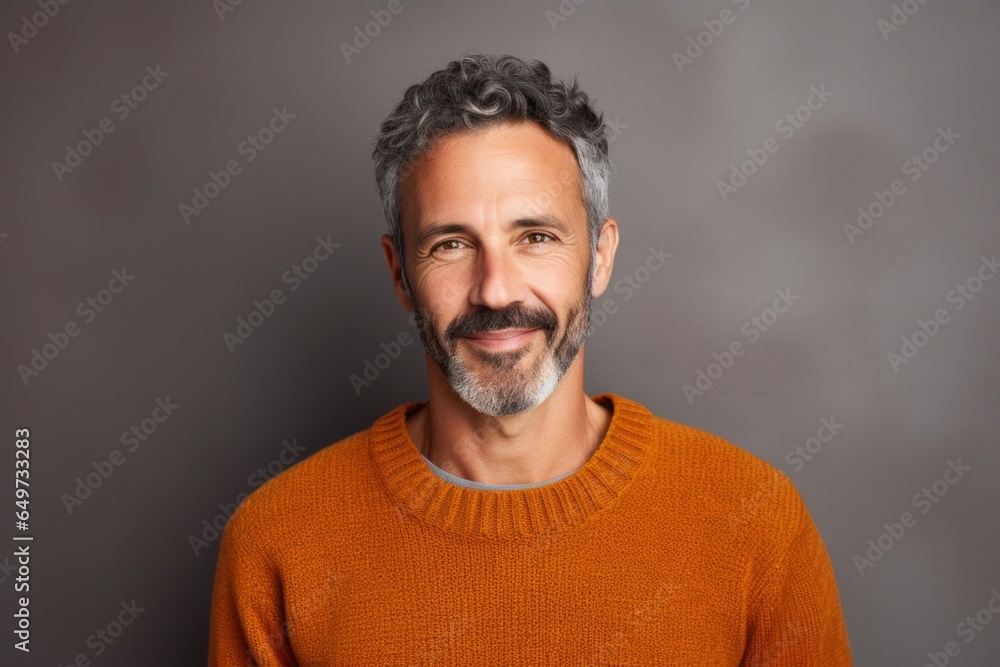 medium shot portrait of a confident Israeli man in his 40s wearing a cozy sweater against an abstract background