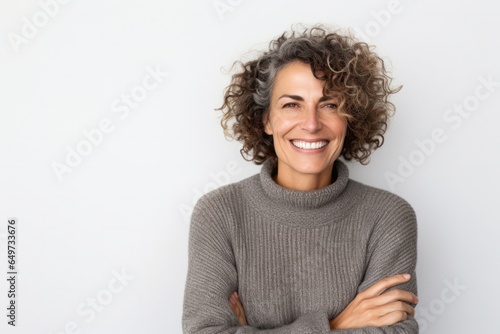 medium shot portrait of a confident Israeli woman in her 40s wearing a cozy sweater against a white background