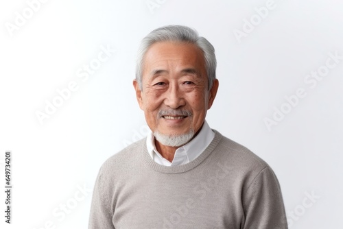 medium shot portrait of a confident Japanese man in his 80s wearing a chic cardigan against a white background © Anne-Marie Albrecht