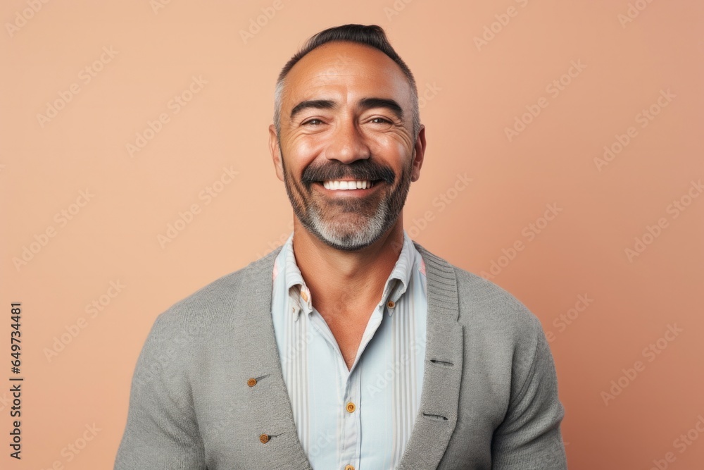 portrait of a Mexican man in his 40s wearing a chic cardigan against a pastel or soft colors background portrait of a Mexican man in his 40s wearing a chic cardigan against a pastel or soft colors background