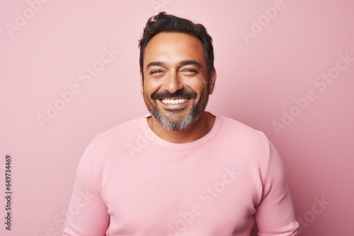 portrait of a Mexican man in his 40s wearing a chic cardigan against a pastel or soft colors background