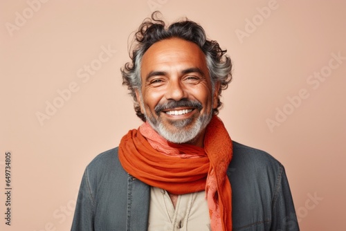 portrait of a Mexican man in his 50s wearing a foulard against a minimalist or empty room background