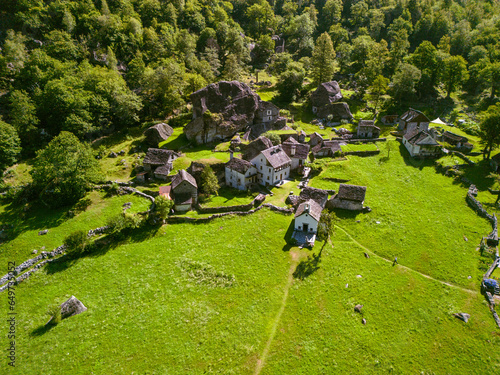 Summertime in an ancient town with stone houses and a waterfall, aerial view of Foroglio, Sabbione, Ticino, Switzerland photo