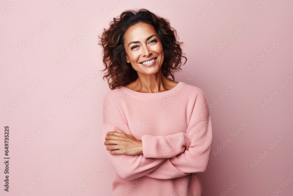 portrait of a Mexican woman in her 40s wearing a cozy sweater against a pastel or soft colors background