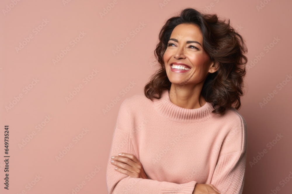 portrait of a Mexican woman in her 40s wearing a cozy sweater against a pastel or soft colors background portrait of a Mexican woman in her 40s wearing a cozy sweater against a pastel or soft colors background