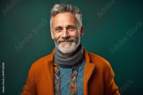 portrait of a Polish man in his 50s wearing a chic cardigan against an abstract background