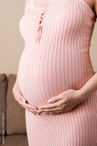 Pregnancy woman in beautiful dress standing on the home