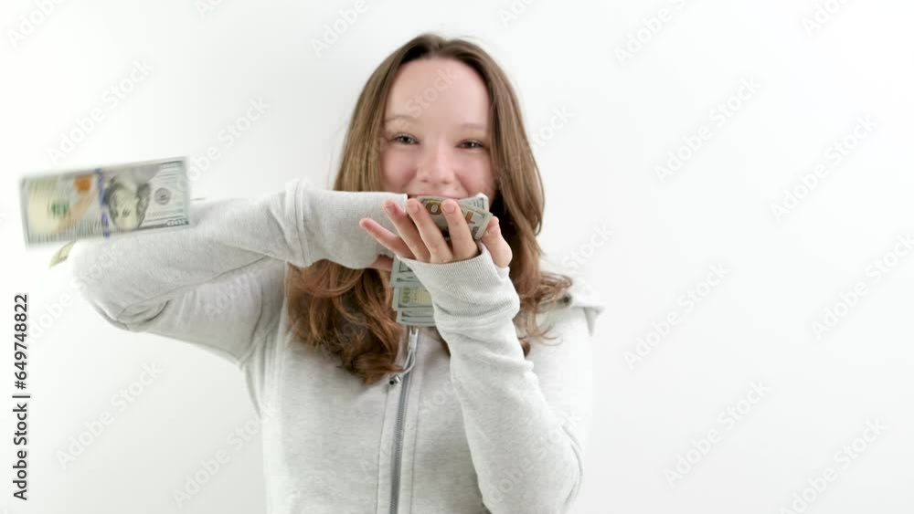 Arrogant wealthy girl scattering dollars with proud haughty expression, boasting rich life, throwing around cash, squandering wasting money carelessly. indoor studio shot isolated Arrogant wealthy girl scattering dollars with proud haughty expression, boasting rich life, throwing around cash, squandering wasting money carelessly. indoor studio shot isolated