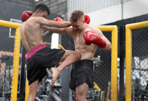 Two male athlete boxing competition in ring. Diverse ethnic men punch fighting in kickboxing exercise in fitness gym. Boxing is fighter sport training need body strength and power fist to knockout.