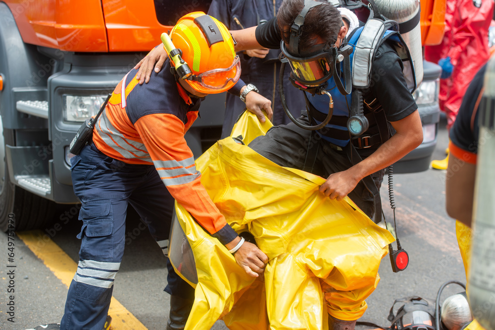 Rescue workers were wearing yellow hazmat suits with oxygen tanks inside. To work in the area of a car accident and toxic leak. Rescue workers were wearing yellow hazmat suits with oxygen tanks inside. To work in the area of a car accident and toxic leak.