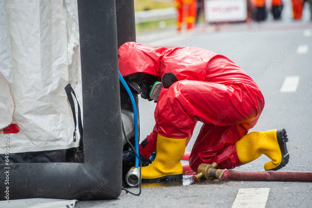 Rescuers wearing red hazmat suits assembled a Inflatable sterilization tunnel tentst. To be used in rescue accidents where toxic substances are leaking.