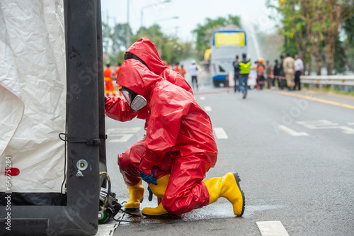 Rescuers wearing red hazmat suits assembled a Inflatable sterilization tunnel tentst. To be used in rescue accidents where toxic substances are leaking.