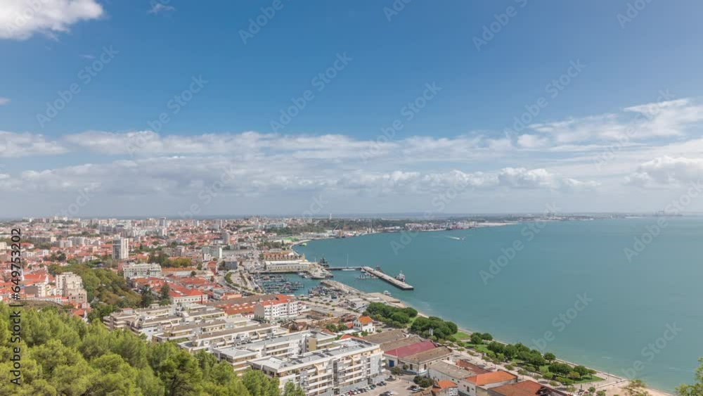 Panorama showing aerial view of marina and city center timelapse in Setubal, Portugal. Red roofs and waterfront with boats and ships from above. Cloudy sky at sunny day Panorama showing aerial view of marina and city center timelapse in Setubal, Portugal. Red roofs and waterfront with boats and ships from above. Cloudy sky at sunny day