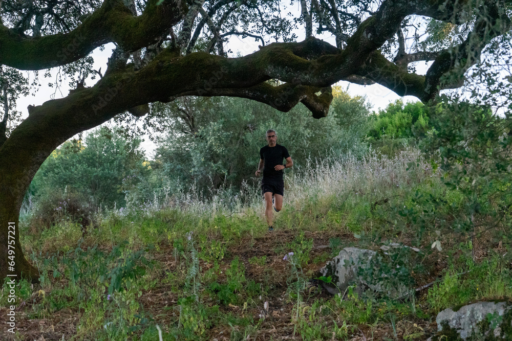 Experienced trail runner with gray hair and sleek black gear, conquering rugged terrain. Experienced trail runner with gray hair and sleek black gear, conquering rugged terrain.