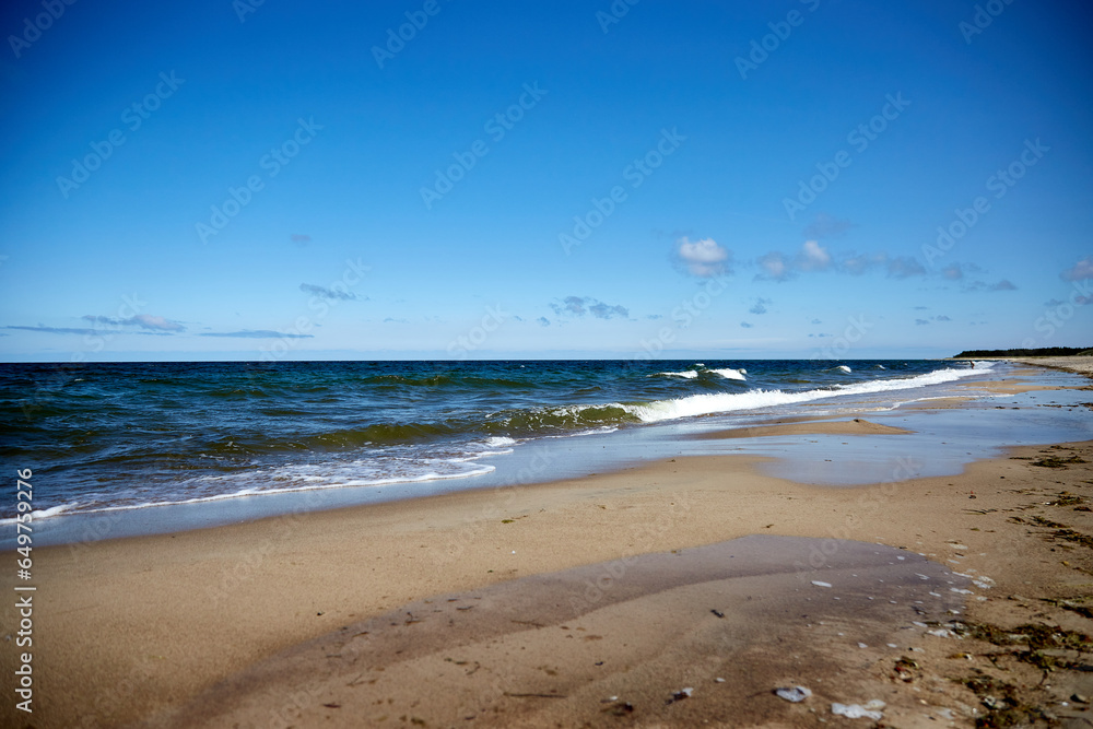 Beautiful beach with sand, tuquoise sea and blue sky with some clouds in synny summer day, selective focus