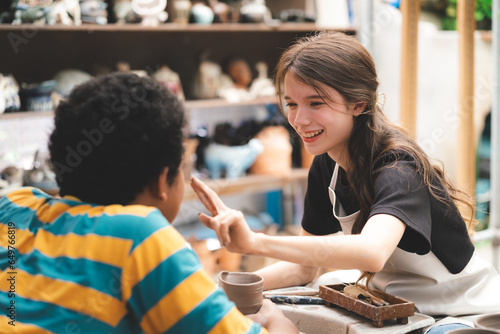 happy smiling girl having fun to learning and work with craft art of clay hand-made workshop in ceramic studio, little ceramist enjoy in creative handcraft hobby with pottery artisan school class