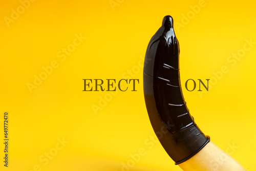 condom dressed on a banana on a yellow background, erection concept, safe sex concept, sexual male health concept photo