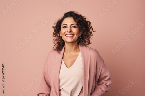 Obraz na płótnie Happy woman with curly brown hair smiling at camera in indoor studio with colored background w salonie