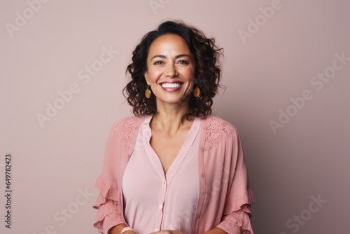 Cheerful woman with curly hair smiling against a vibrant colored background