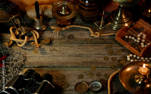 Treasure island concept on a wooden table background. Frame from vintage marine objects around wooden background in the center