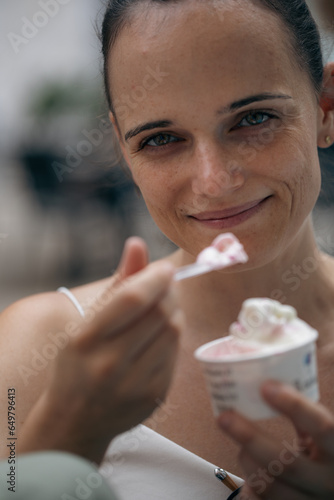 Young women enjoying ice cream. Looking to the camera. Smiling. Holidays. Having fun. Enjoying life.