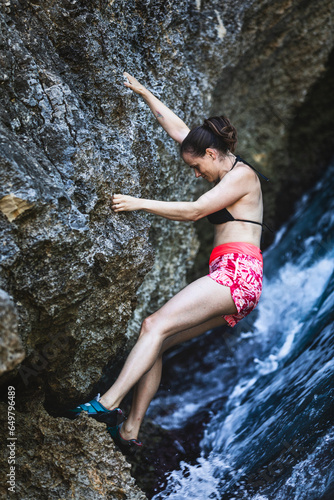 Action loaded sport scene, women climbing over the sea, no ropes, action packed.