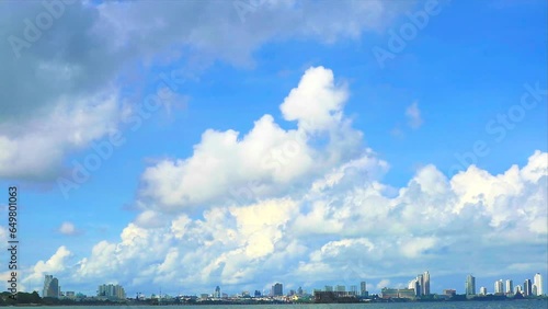 Heap beautiful white cloud blue sky huge rollong over the sea and building of the city in the rainy season photo