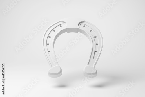 White horseshoe floating in mid air on white background in monochrome and minimalism. Illustration of the concept of horse racing and equestrian