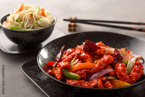 Dragon chicken include bell pepper, red chilli and carrot and chowmein with chopsticks served in dish isolated on background top view of chinese food photo