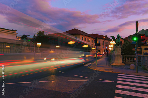 Sunrise landscape view of ancient city center of Ljubljana. Dragon bridge (Zmajski most) across Ljubljanica River. Symbol of Ljubljana, capital of Slovenia, Europe. Blurred motion photo