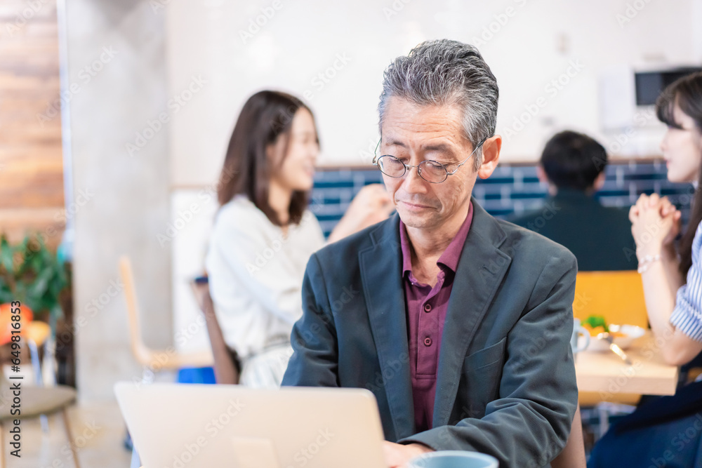 Obraz premium カフェで仕事をする中年男性