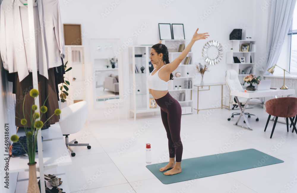 Slim woman standing and doing yoga exercise at home Slim woman standing and doing yoga exercise at home