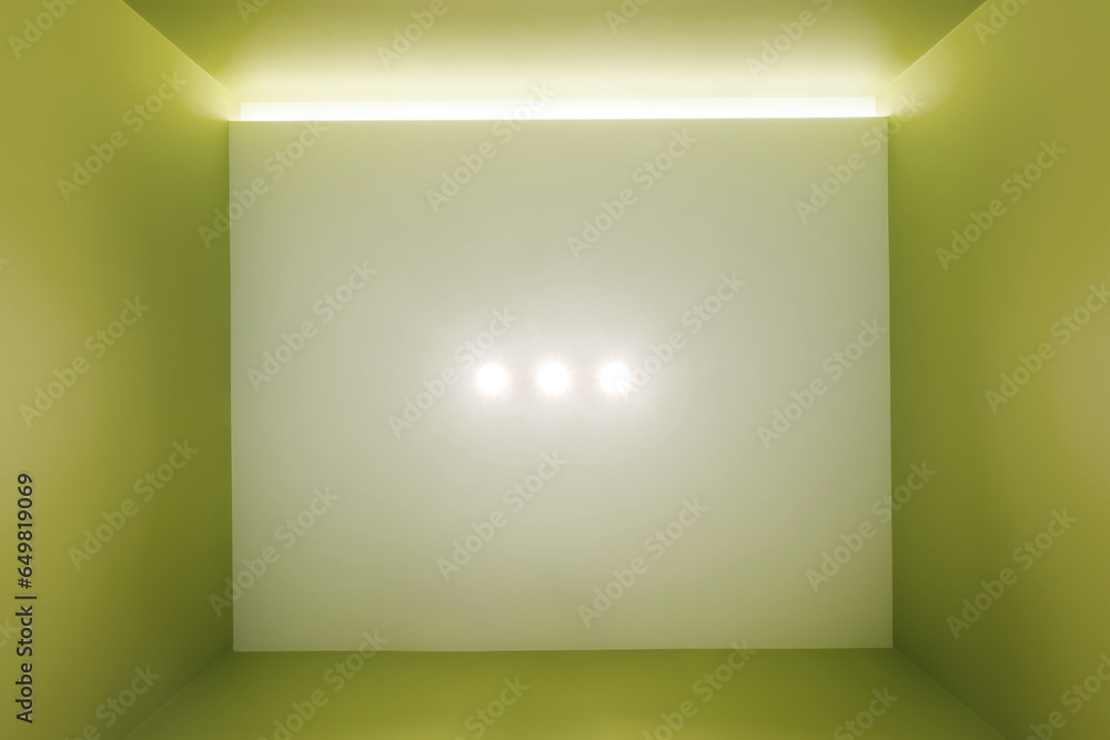 suspended ceiling with halogen spots lamps and drywall construction in empty room. Stretch ceiling white and complex shape. suspended ceiling with halogen spots lamps and drywall construction in empty room. Stretch ceiling white and complex shape.
