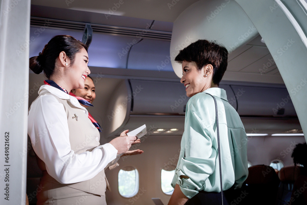 Beautiful Asian female air hostess standing at airplane entrance gate, flight attendant woman welcome and check passenger before boarding, cabin crew work in airplane, traveling Airline transportation Beautiful Asian female air hostess standing at airplane entrance gate, flight attendant woman welcome and check passenger before boarding, cabin crew work in airplane, traveling Airline transportation
