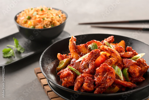szechuan prawn include bell pepper, tomato, spring onion with schezwan fried rice and chopsticks served in bowl top view of chinese food photo